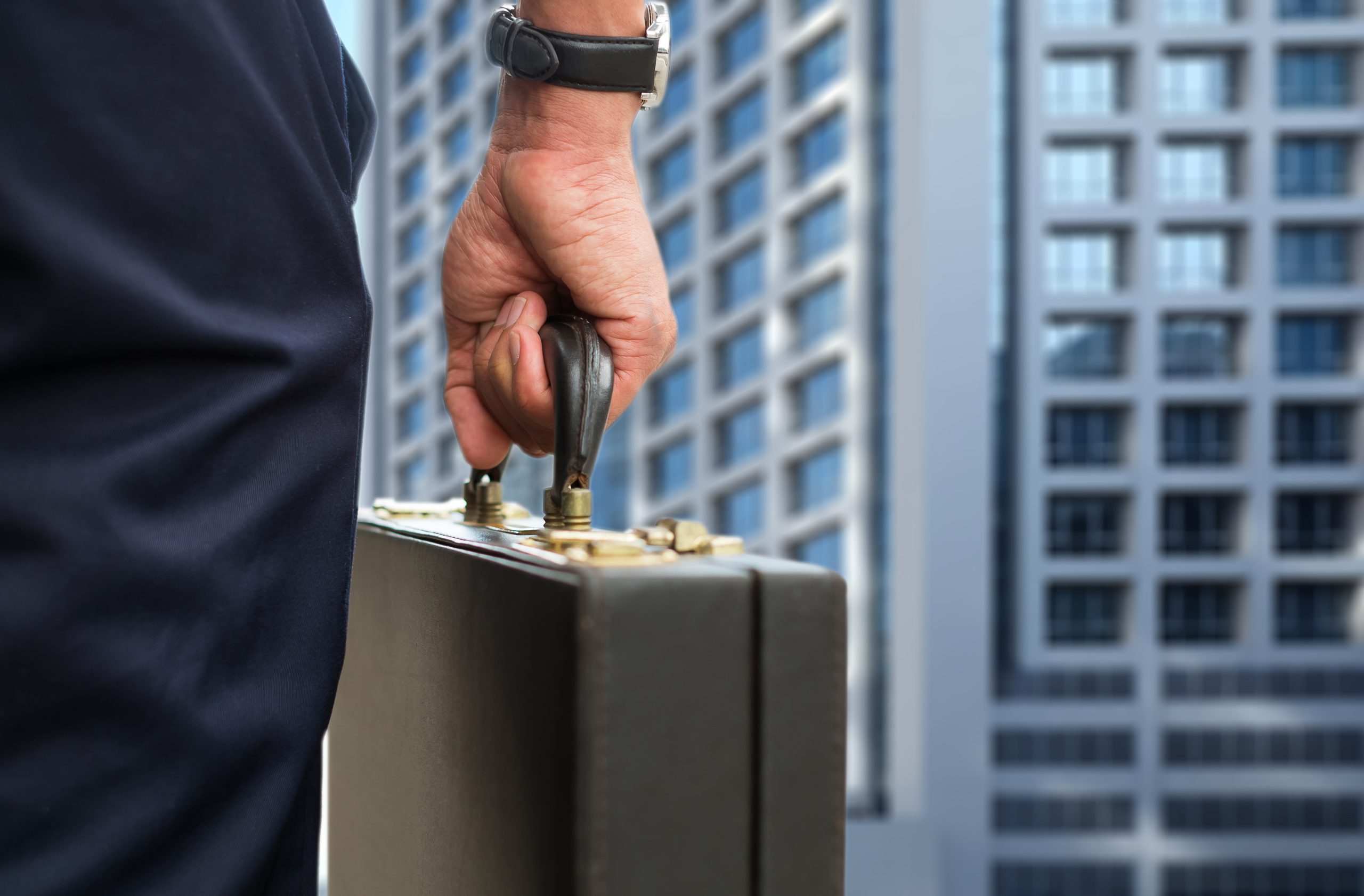 Mężczyzna w garniturze trzymający aktówkę, symbolizujący zarządzanie funduszami inwestycyjnymi zamkniętymi na rynku kapitałowym