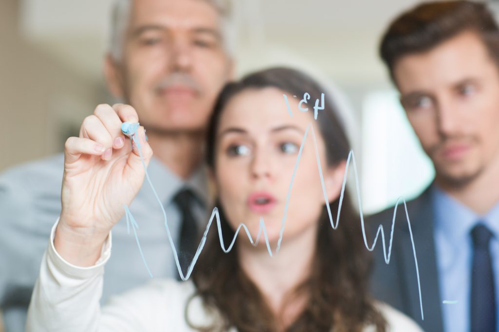 ludzie rysują na tablicy wykres - doradztwo majątkowe